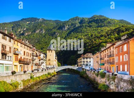 Scenische Flussansicht traditioneller Almhütten entlang des Isère-Ufers in der Stadt Moutiers in Frankreich Stockfoto