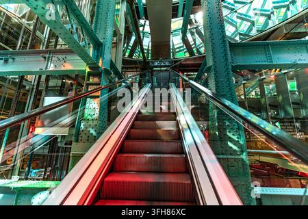 Rot beleuchtete Rolltreppe steigt durch das genietete Stahl- und Glasatrium im Guinness Storehouse in Dublin, Irland Stockfoto