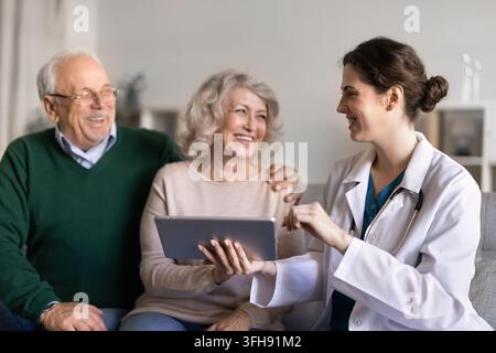 Lächelnde Ärztin, die ein älteres Ehepaar berät Stockfoto