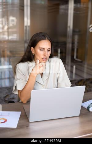 Konzentrierte Geschäftsfrau analysiert Daten auf dem Laptop im Büro Stockfoto