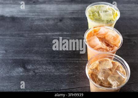 Eine Ansicht von drei eiskalten Getränken in Plastikbechern, grünem Thai-Tee, vietnamesischem Kaffee und Thai-Tee, auf der rechten Seite des Bildes. Stockfoto