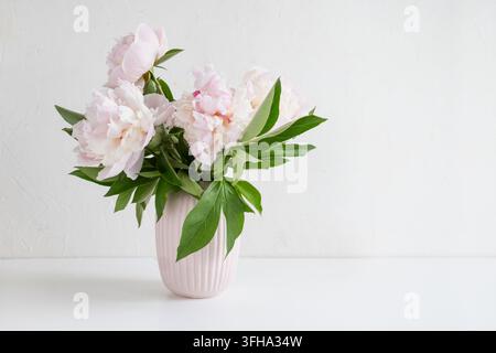 Rosa Pfingstrosen in einer Pastellvase auf weißem Hintergrund Stockfoto