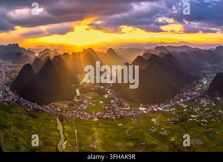 Dramatischer goldener Sonnenuntergang über das Bac-Son-Tal mit Kalkstein-Karstbergen und grünen Reisfeldern in der Provinz Lang Son, Nordvietnam. Stockfoto