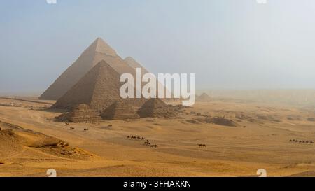 Majestätische Pyramiden von Gizeh in der ägyptischen Wüste unter einer nebligen Atmosphäre Stockfoto