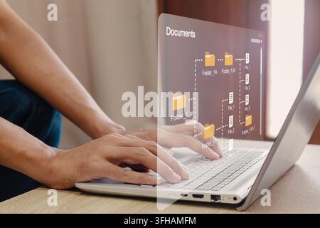 Eine Person, die einen Laptop verwendet, um ein strukturiertes digitales Ordnersystem zu navigieren. Dokumentenverwaltungssystem. Stockfoto