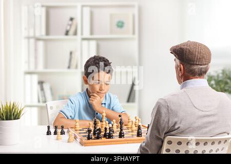 Opa und Enkel spielen zu Hause Schach Stockfoto