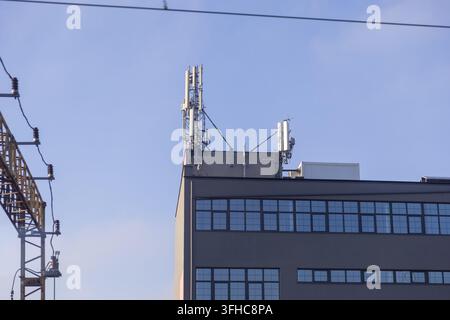Metallantennen und Funksender, die auf einem Dach montiert sind, sorgen für Hochgeschwindigkeits-Internet und Signalabdeckung und unterstreichen die essentielle Konnektivität eines Stockfoto