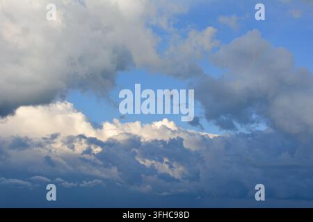 weiße und dunkelblaue Wolken am blauen Himmel Stockfoto