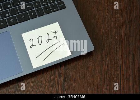 Haftnotiz mit 2027 auf Laptop auf Holzschreibtisch, Kopierplatz Stockfoto