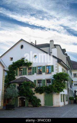 Traditionelles Haus auf der Place du Château in der Nähe des Schlosses Nyon in Nyon, Waadt, Schweiz, abends fotografiert Stockfoto