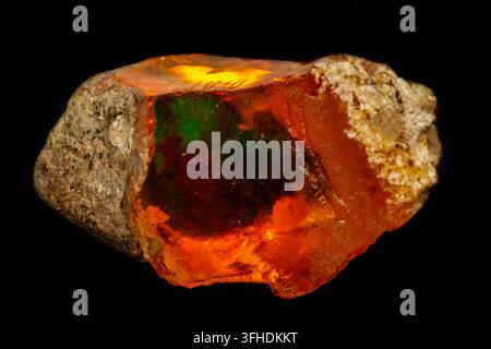 Makro Opal-Mineralstein in Gestein auf schwarzem Hintergrund Nahaufnahme Stockfoto