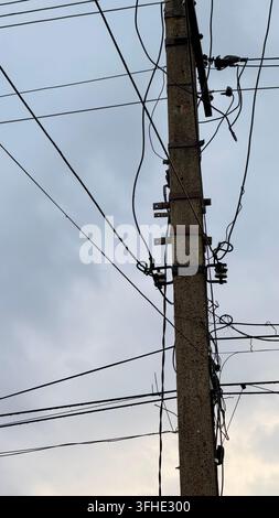 Strommast und Freileitungen vor einem bewölkten Himmel, mit großzügigem negativem Raum für Infrastruktur-, Telekommunikations- und Energiekonzepte. Stockfoto