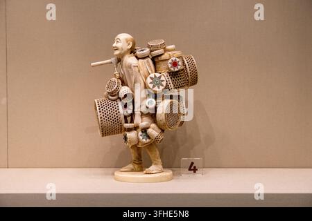 Bukarest, Rumänien - 6. Nov 25: Kleine Elfenbeinstatue eines lächelnden Verkäufers mit Körben, ausgestellt im Nationalmuseum für Kunst in Bukarest, Ro Stockfoto