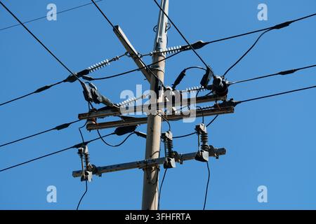 Strommast und Freileitungen unter blauem Himmel Stockfoto