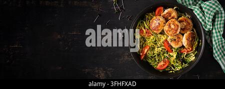 Zucchini-Spaghetti mit Hähnchenfleischbällchen in der Pfanne. Draufsicht. Banner Stockfoto