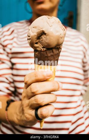 Frau hält eine Schokoladeneiswaffel und genießt einen erfrischenden Moment im Urlaub Stockfoto