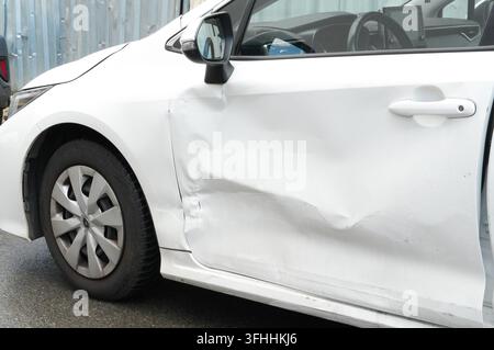 Weißes Auto mit beschädigtem Heckstoßstangen, Nahaufnahme. Auto nach einem Unfall Stockfoto