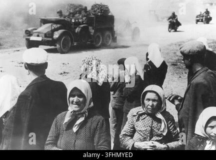 Dorfbewohner beobachten einen Konvoi deutscher Militäreinheiten an der Ostfront, 1941. Stockfoto