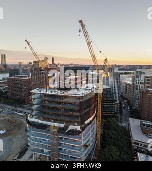 Luftaufnahme eines Hochhauses im Bau mit zwei großen gelben Turmkranen, die über das Stahlgerüst im Kendall Square, Cambridg, ragen Stockfoto