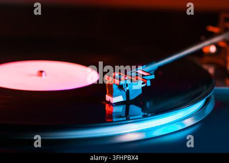 1327 - Blick von einem sich drehenden Record vinyl Player. Close Up. Von der Seite. Bunter Film mit Neonlicht Stockfoto