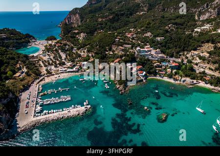 Luftbild-Drohnenaufnahme der Bucht von Paleokastritsa, herzförmige Küste mit klarem, blaugrünem Meerwasser. Griechenland, Korfu-Insel. Luxusresortdorf Stockfoto