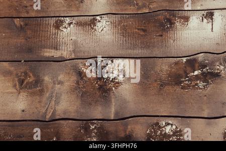 Nasse Holzplanken mit kleinen Pfützen, die das Licht reflektieren Stockfoto