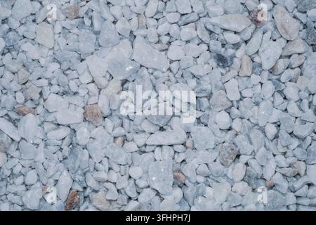 Textur aus grauem und weißem Schotter oder kleinen Steinen. Dichte gleichmäßige Hintergrund mit unregelmäßigen Gesteinsfragmenten Stockfoto