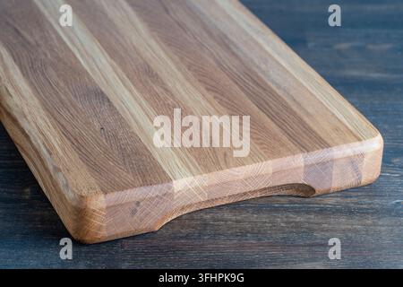 Holzschneidebrett auf hölzernem Tischhintergrund, Nahaufnahme Stockfoto