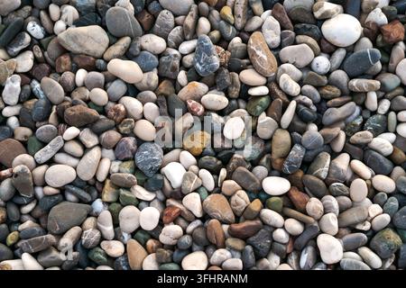 Glatte runde nasse Kieselsteinstruktur-Hintergrund. Kieselstein-Meeresstrand-Nahaufnahme. Stockfoto