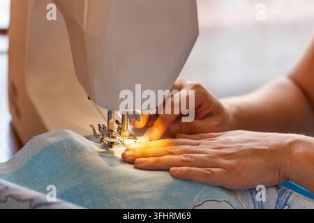 Frau näht auf einer Nähmaschine Stockfoto