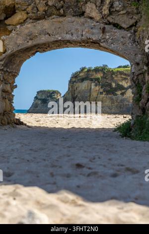 Gelbe Felsen und Klippen am Sandstrand. Eine Bucht am Meer, Praia da Caldeira, Lagos. Algarve, Portugal Stockfoto