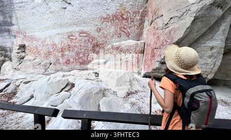BRISBANE - 08. AUG 2023: Australischer Teenager betrachtet die Kunstgalerie der Ersten Völker Australiens in Carnarvon Gorge, Queensland, Australien. Mount Moffatt Stockfoto