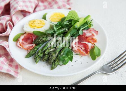 Spargelsalat mit Schinkenscheiben und gekochten Eiern. Stockfoto