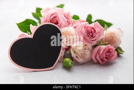 Rosa Rosen mit herzförmiger Tafel für den Valentinstag oder den Muttertag Stockfoto