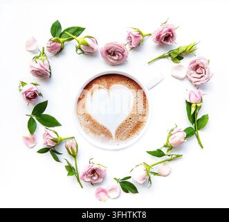 Morgen Tasse Kaffee und schöne Rosenblüten auf weißem Hintergrund, Draufsicht. Gemütliches Frühstück. Flach liegend Stockfoto