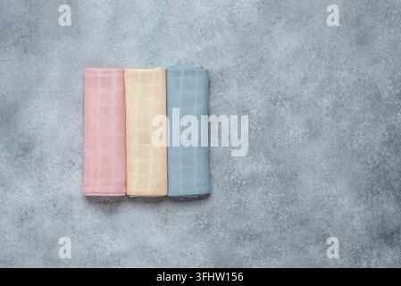 Farbige Baumwollservietten auf einem grauen Betonhintergrund. Oberblick, Flat Lay. Stockfoto