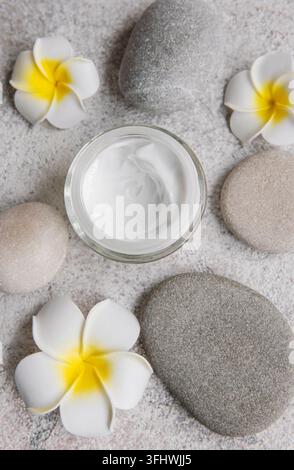Spa-Behandlung mit Massagesteinen und feuchtigkeitsspendender Creme Stockfoto