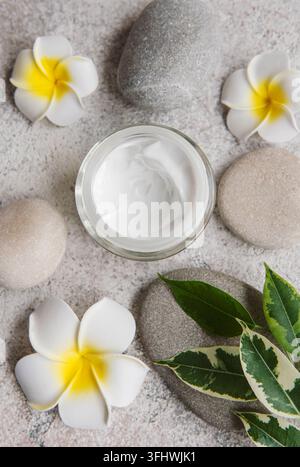Spa-Behandlung mit Massagesteinen und feuchtigkeitsspendender Creme Stockfoto