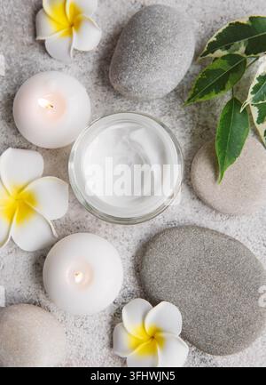Spa-Behandlung mit Massagesteinen und feuchtigkeitsspendender Creme Stockfoto