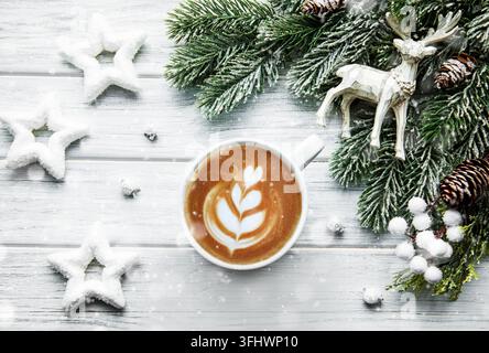 Weihnachtskarte mit Tasse Kaffee, Kiefer, Tanne auf weißem Holzhintergrund, Draufsicht Stockfoto