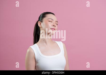 Gelassene asiatische Frau mit geschlossenen Augen, die frische Haut für Schönheit und Hautpflege-Wellness genießt Stockfoto