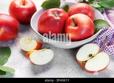 Rote Äpfel in einer Schüssel mit Scheiben auf dem Tisch Stockfoto