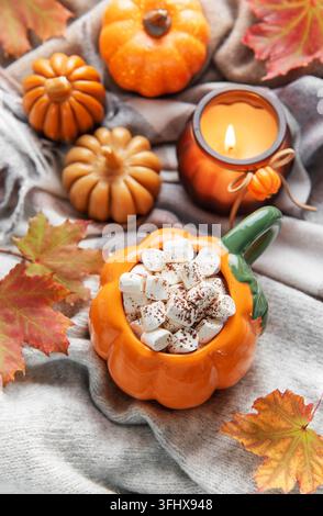 Kürbistasse mit heißer Schokolade und Marshmallows, gemütliche Herbstszene Stockfoto