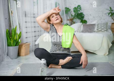 Reife Frau ruht auf Gymnastikmatte nach Fitness-workout Stockfoto