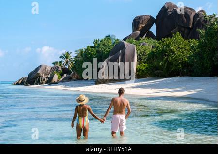 Ein paar Spaziergänge Hand in Hand entlang des ruhigen Wassers des Anse Source d'Argent Strandes, umgeben von majestätischen Granitblöcken und üppigem Grün. Ein Perfec Stockfoto