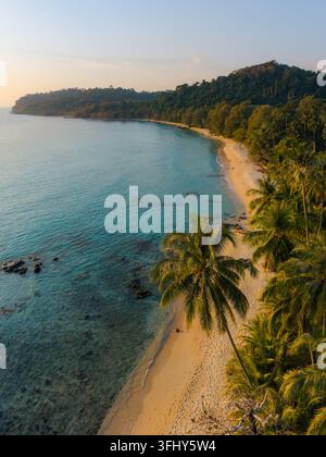Erleben Sie die Ruhe des Takhian Beach auf Koh Kood, Thailand, während die Sonne über dem ruhigen Wasser untergeht und eine malerische Szene schafft. Stockfoto