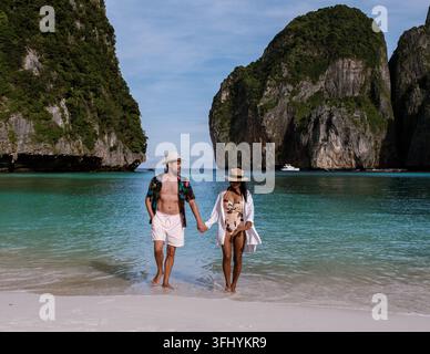 Ein paar Spaziergänge Hand in Hand entlang des weichen Sandstrandes von Koh Phi Phi, umgeben von atemberaubenden Kalksteinklippen der Maya Bay, Krabi, Thailand. Dies Stockfoto