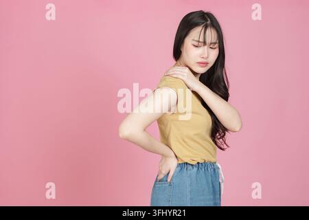 Frau mit Schulter- und Rückenschmerzen, die ihren Nacken halten Stockfoto