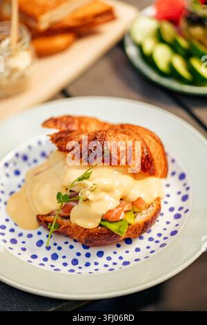 Herzhaftes Croissant mit Lachs, Avocado und Hollandaise-Sauce Stockfoto