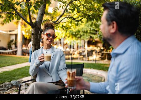 Erwachsene Frau und Mann teilen Kaffee in einem Café im Freien Stockfoto
